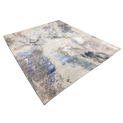 Abstract designer rug in a diagonal view: beige/gray with blue and turquoise
