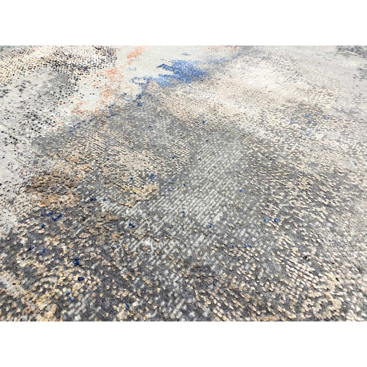 Abstract designer rug close-up: textured surface in beige/gray with blue