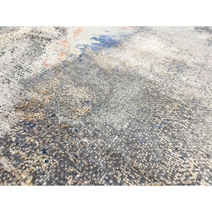 Abstract designer rug close-up: textured surface in beige/gray with blue