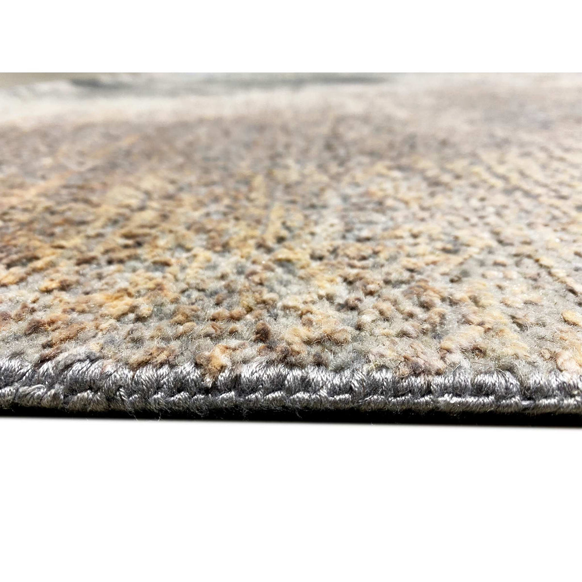 Abstract designer rug detail: pile and bound edge, mottled beige-gray