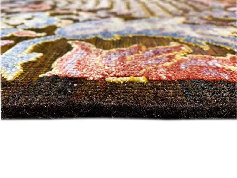 Carpet pile at the edge, dense and darkly backed, multicolored pattern in the foreground.