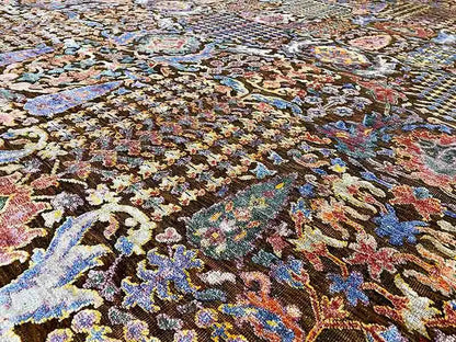 Carpet surface with a fine, multicolored ornamental pattern and textured pile.