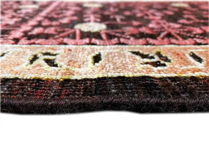 Close-up of a carpet edge: dark pile with a light ornamental band and fine details