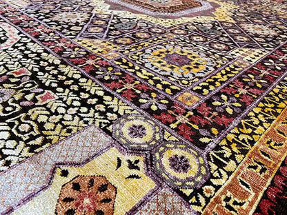 Rug with an intricate ornamental design in black, yellow, red, and cream