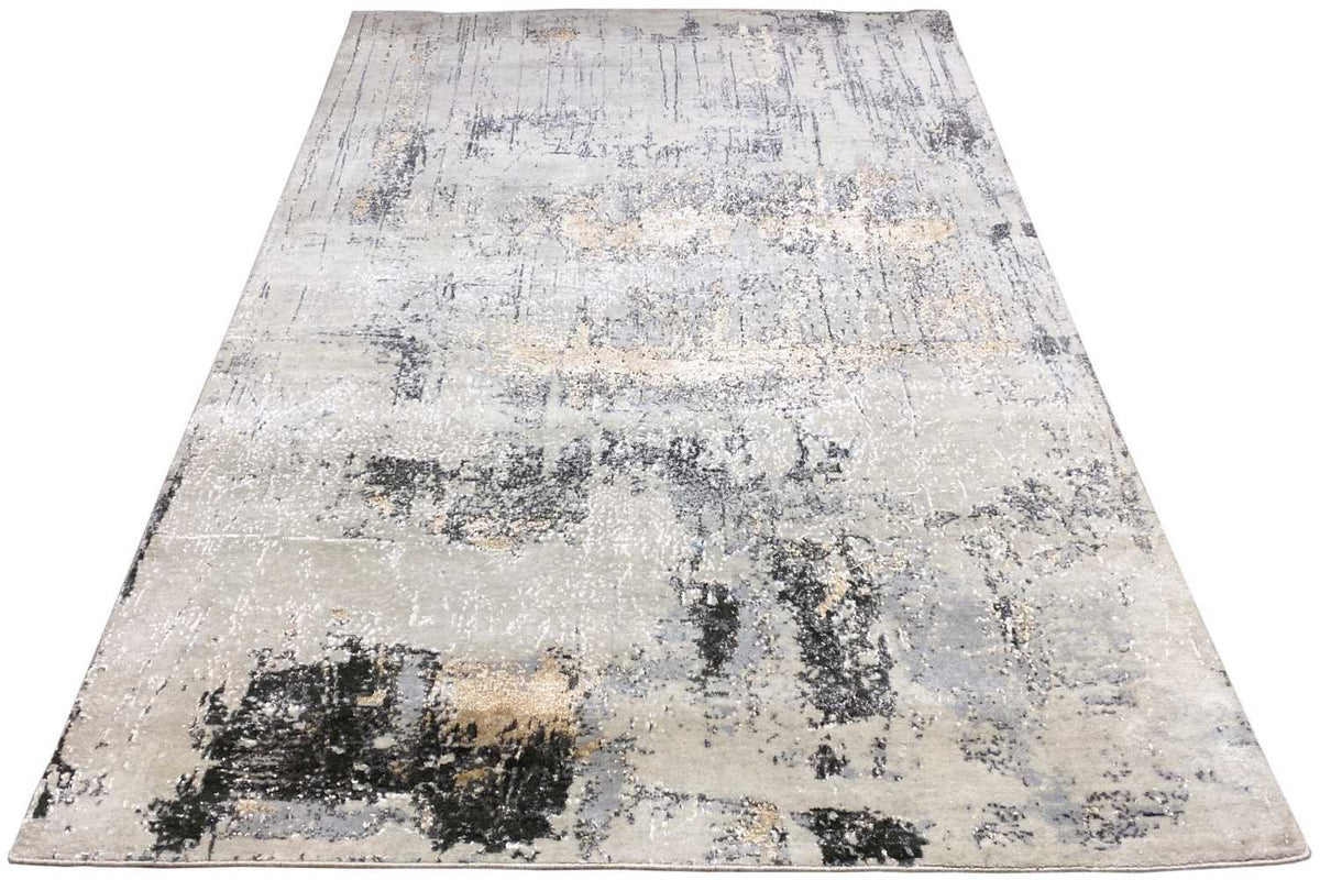 Rectangular rug with abstract color patches in light beige, gray, and black