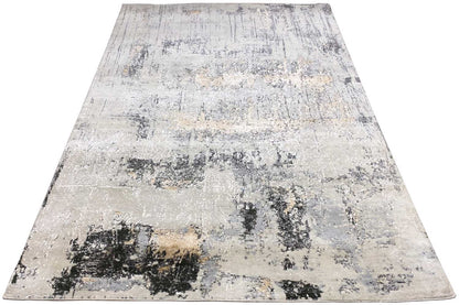Rectangular rug with abstract color patches in light beige, gray, and black