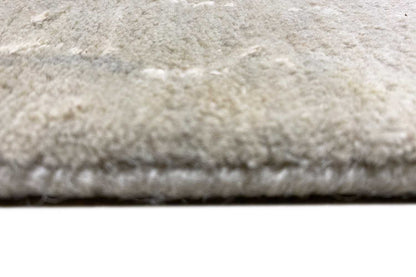 Close-up of a carpet edge with a dense pile texture on a light beige background