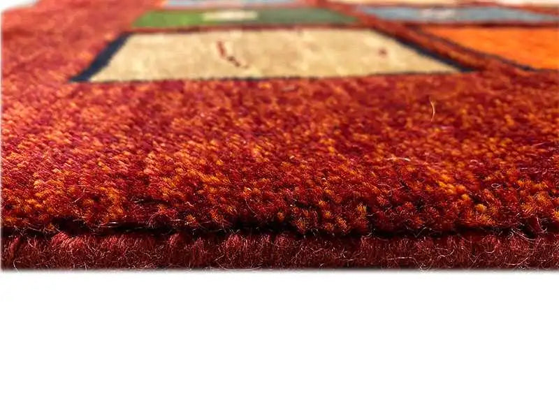 “Lori” Gabbeh rug with a dense pile in vibrant red, side edge visible