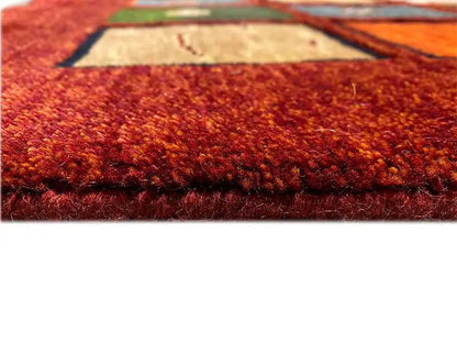 “Lori” Gabbeh rug with a dense pile in vibrant red, side edge visible