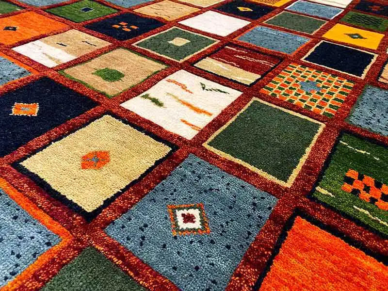 Gabbeh rug “Lori” close-up: square patterns in orange, blue, green and white