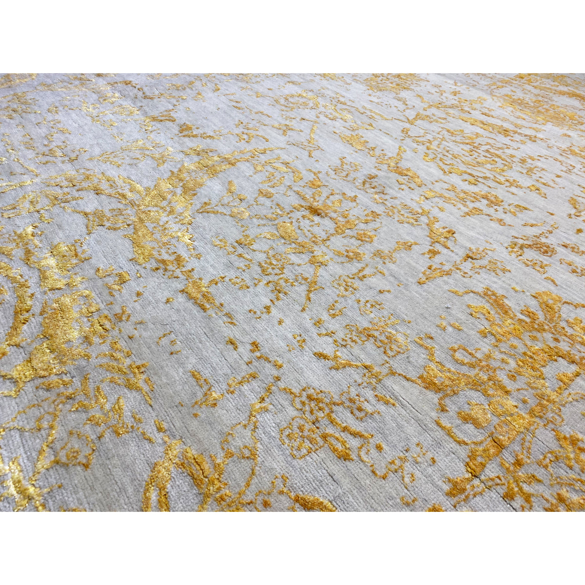 Close-up view of designer rug 316x245 cm: gold floral pattern on a light background