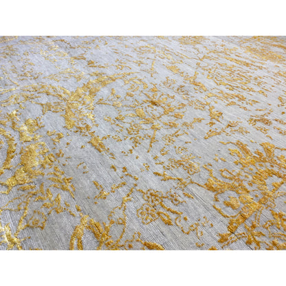 Close-up view of designer rug 316x245 cm: gold floral pattern on a light background