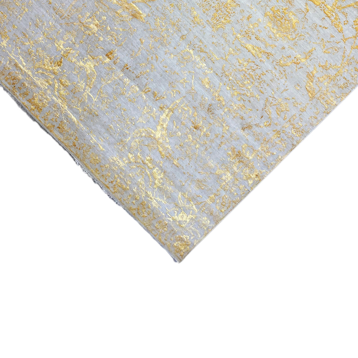 Designer rug 316x245 cm, detail of the diagonal edge with a gold-colored ornamental pattern