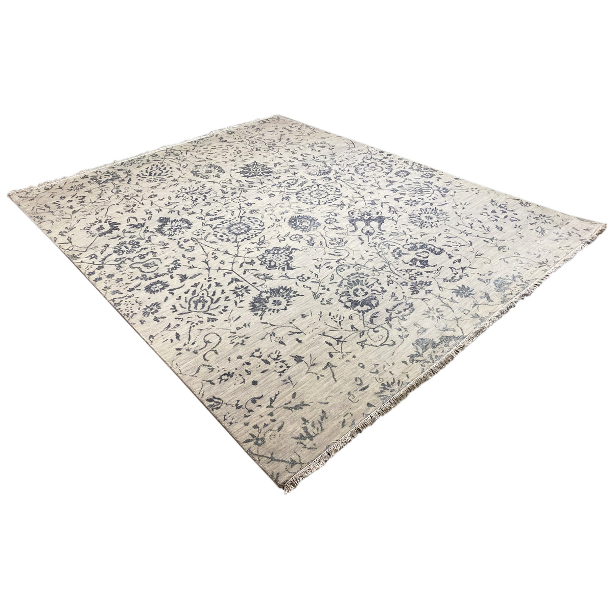 Corner view: Designer rug with a blue decorative pattern on a light background, appearing square-shaped