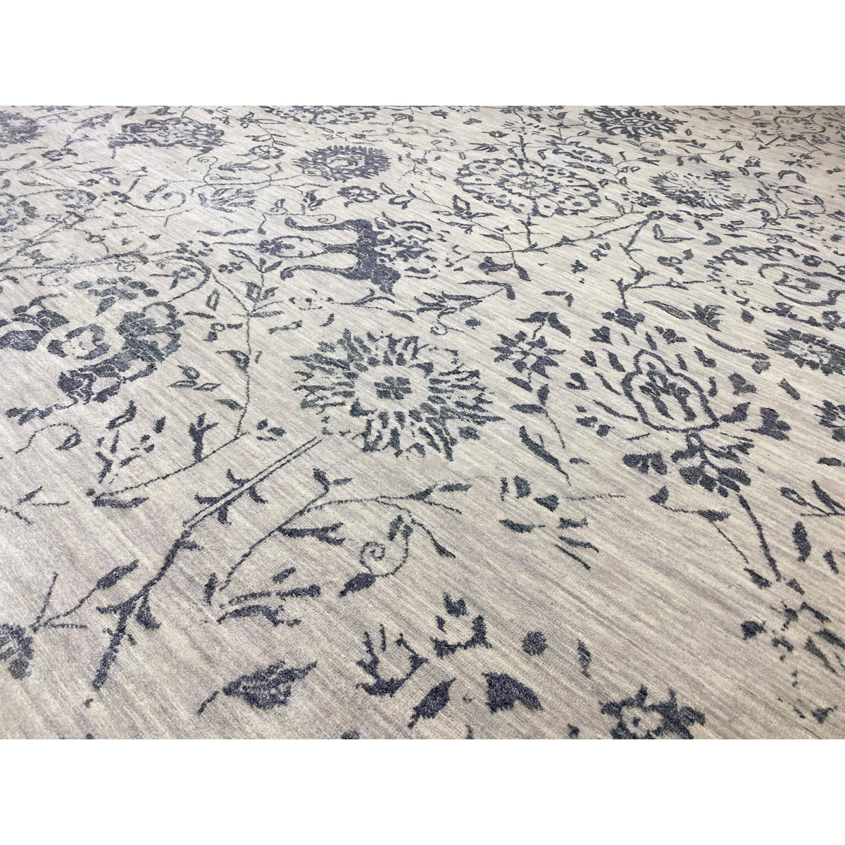 Close-up: Blue ornamental pattern on light-colored fabric, decorative lines and floral motifs