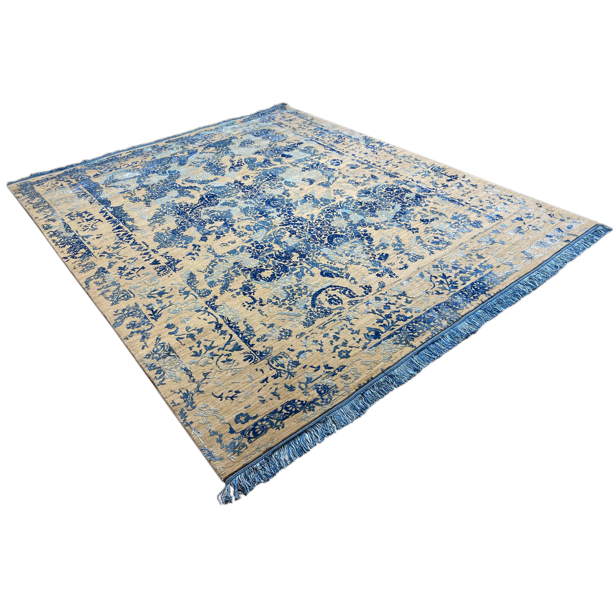 Rug in diagonal view: beige surface with blue ornament and bordered edge
