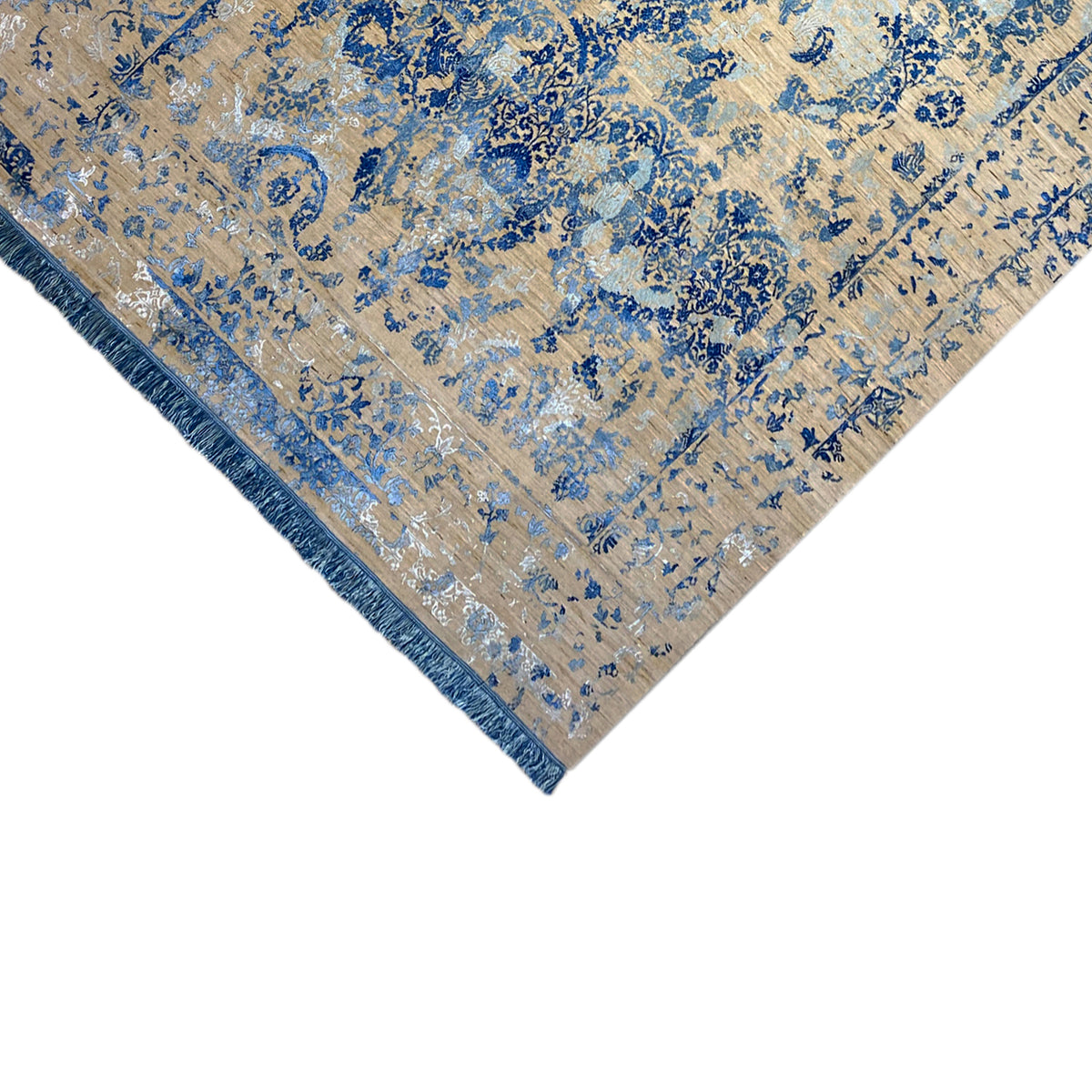 Triangular view of the rug with a blue pattern, beige base, and fringes