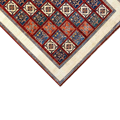 Close-up of the carpet’s center: diamond and tile patterns in blue and red, with a cream-colored border