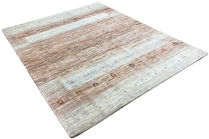 Gabbeh rug from an angled view: vintage stripes in brown, beige, and light blue