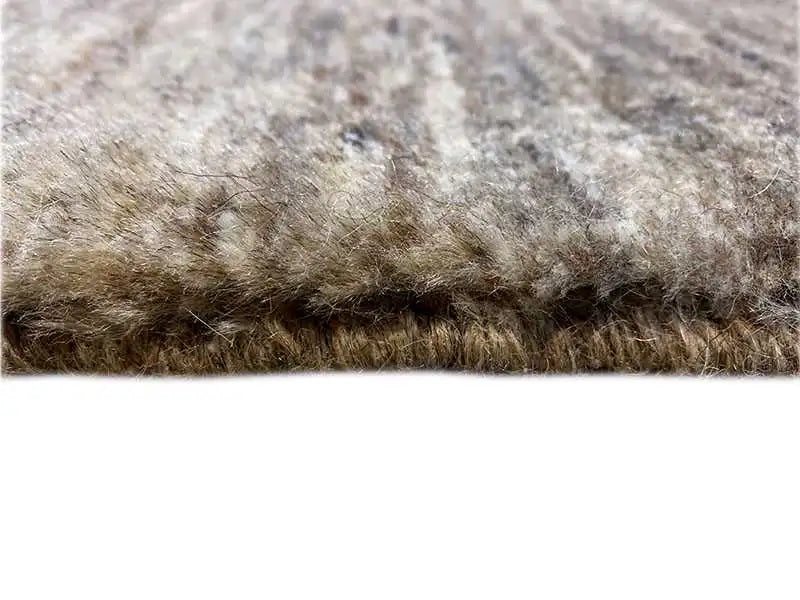Close-up: carpet edge with short, mottled gray-brown pile