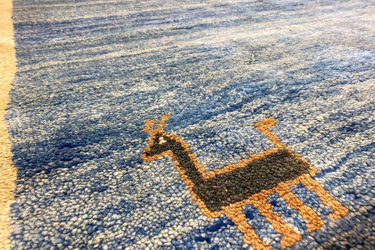 Carpet detail with woven border and stylized figure elements in blue and orange