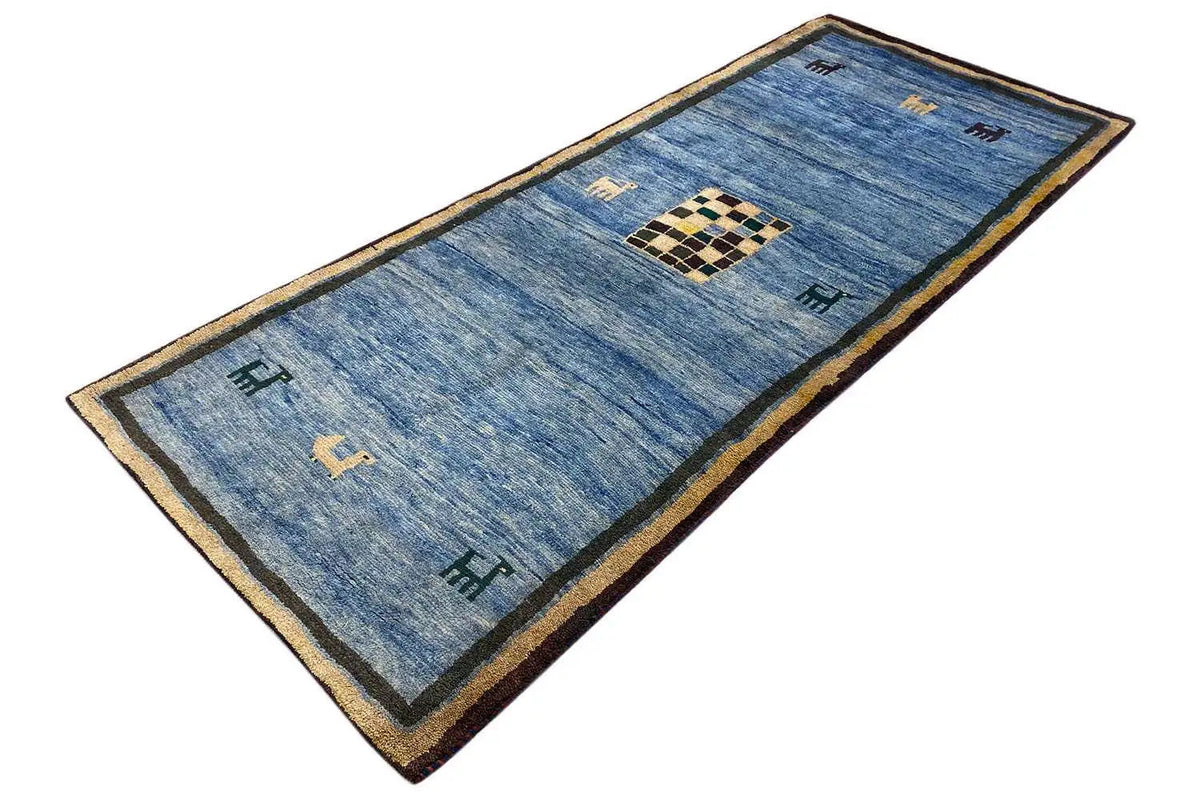 Blue Gabbeh rug with corner frame, beige border, and checkered central motif