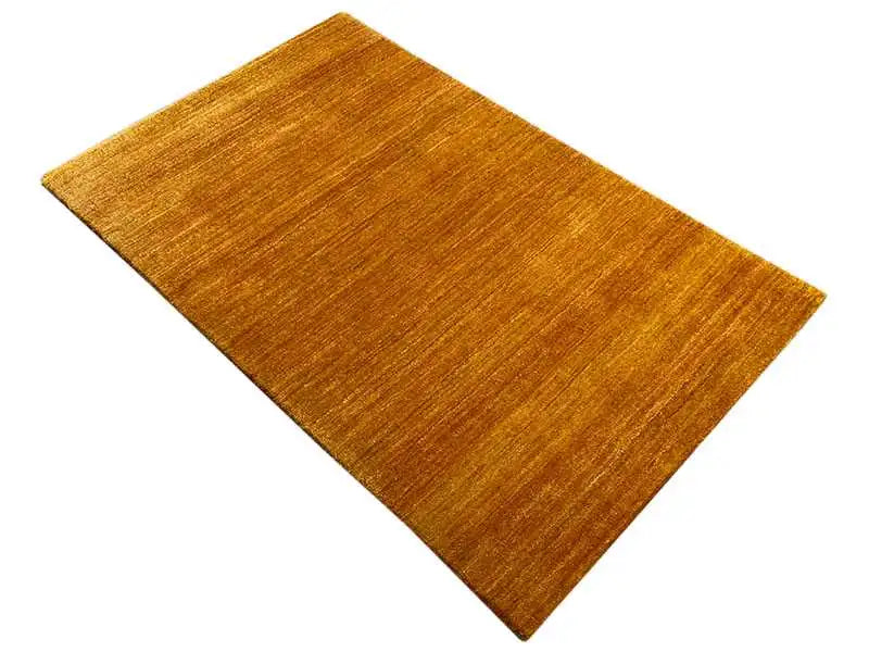 Ochre rectangular rug, viewed from above at an angle, fine pile lines