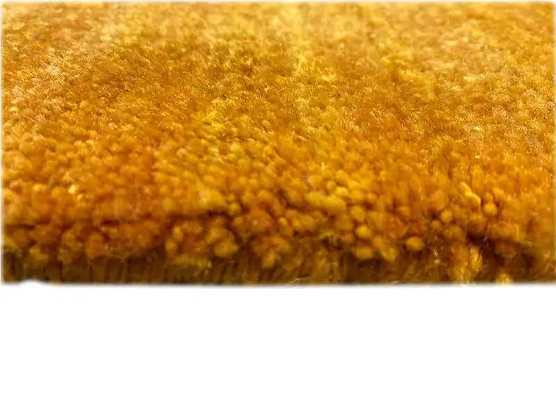 Close-up of an ochre carpet: dense pile and edge area