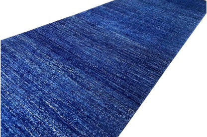 Close-up of a blue runner rug: mottled fibers, fine horizontal texture