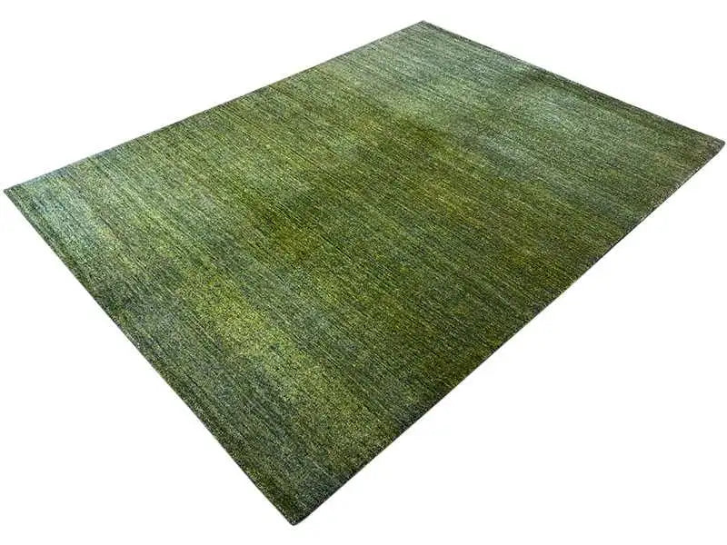 Gabbeh rug in mottled vibrant green, fine linear texture, lies flat