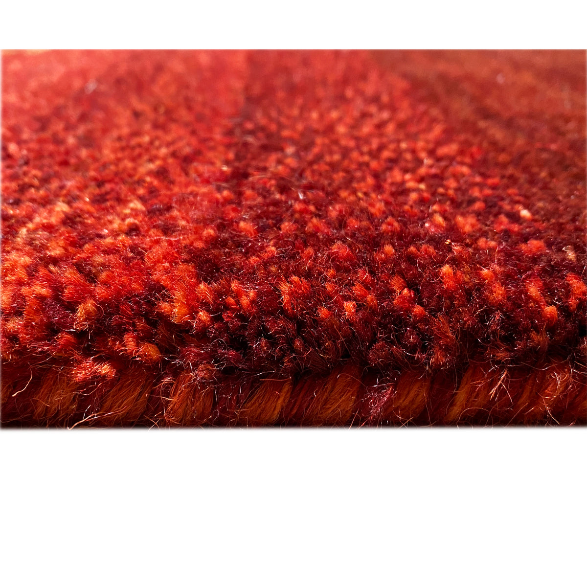 Gabbeh rug with a dense red pile and a fine, speckled texture