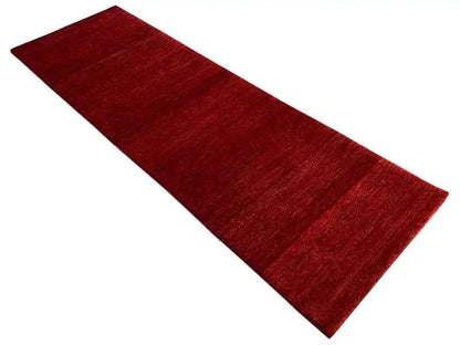 Gabbeh rug runner, dark red surface with a fine mottled texture