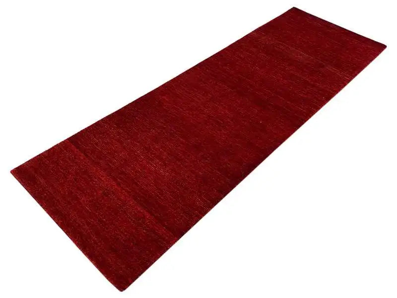 Gabbeh runner rug with a dark red hue and an even woven pattern