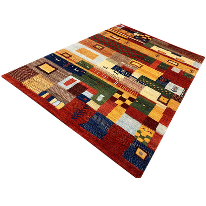 Gabbeh rug with a square patchwork pattern in warm red, yellow, and blue tones