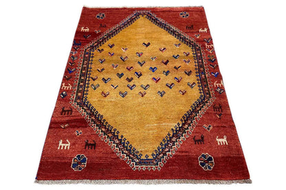 Gabbeh rug with a red border and beige central medallion, geometric pattern