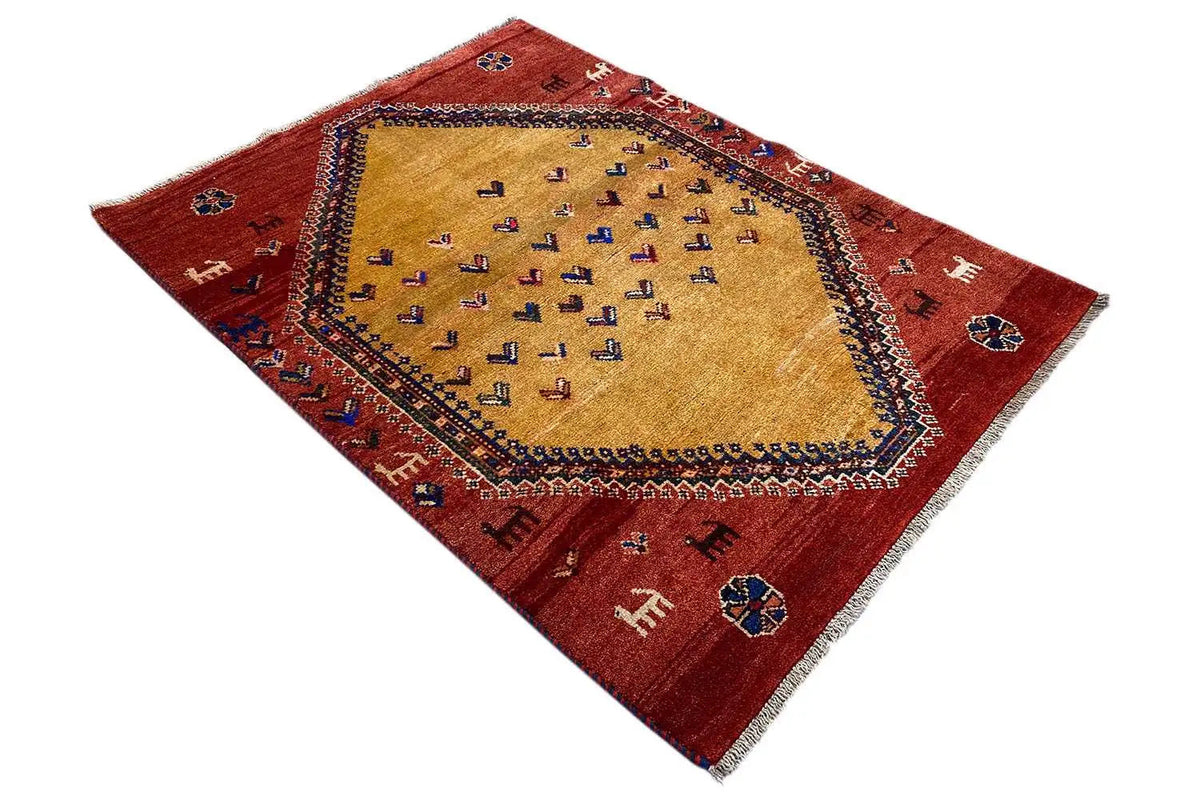 Gabbeh rug laid flat: red center with a beige medallion and border