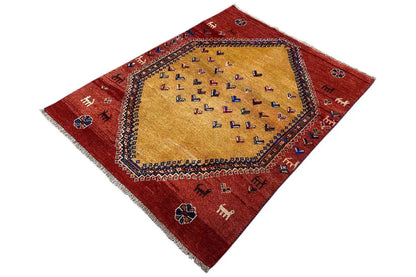 Gabbeh rug with a red ground, beige central medallion, and blue-accented border