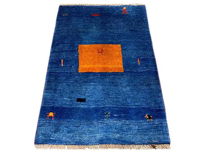 Blue Gabbeh rug with an orange rectangular pattern and colorful details, with fringes