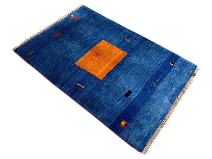 Blue carpet with an orange rectangle in the center, diagonal view, fringes along the edges