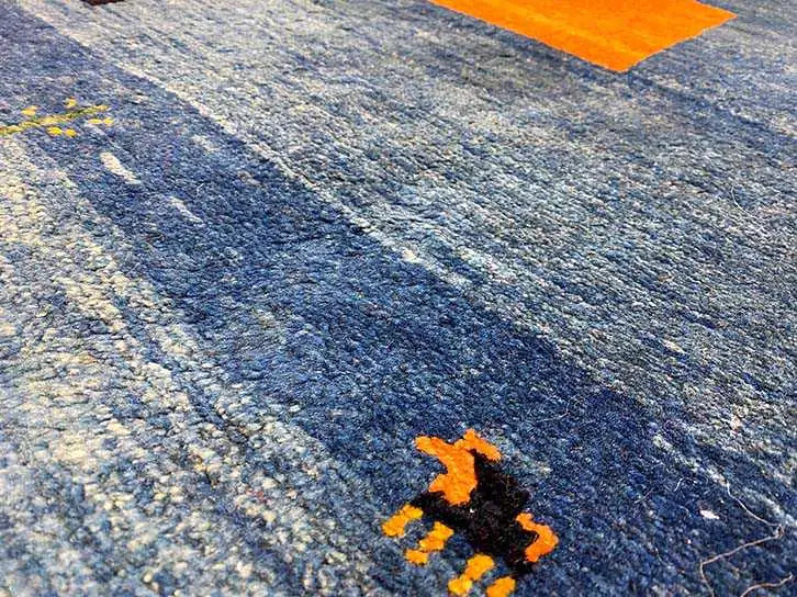Texture detail of the blue carpet with orange accents and woven-in patterns