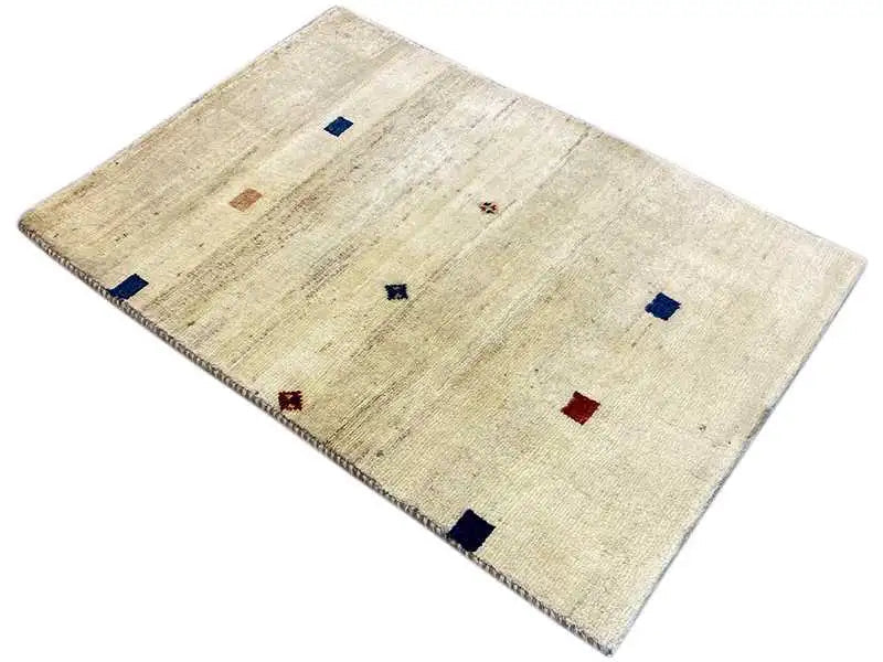 Gabbeh rug 119x84 cm, light beige, laid at an angle with blue and red pattern elements