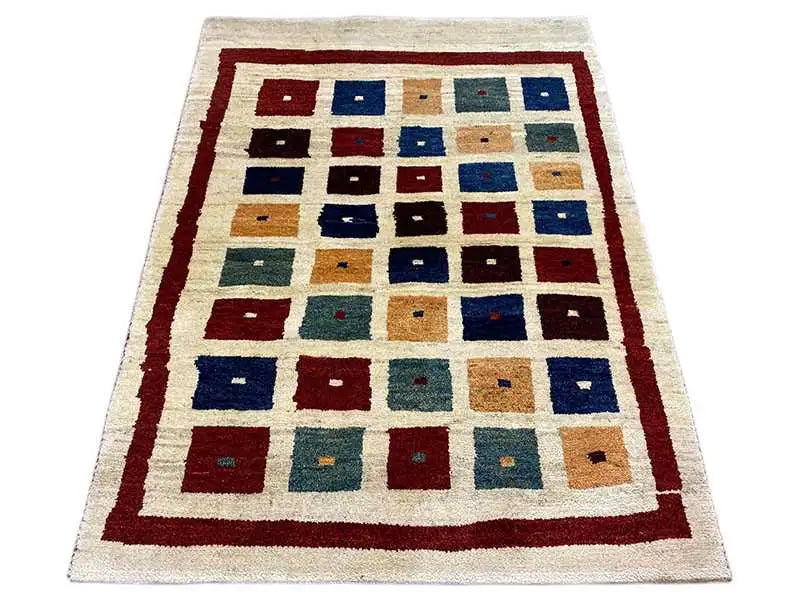 Gabbeh rug with a square patchwork pattern in blue, red, and beige