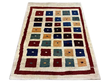 Gabbeh rug with a square patchwork pattern in blue, red, and beige