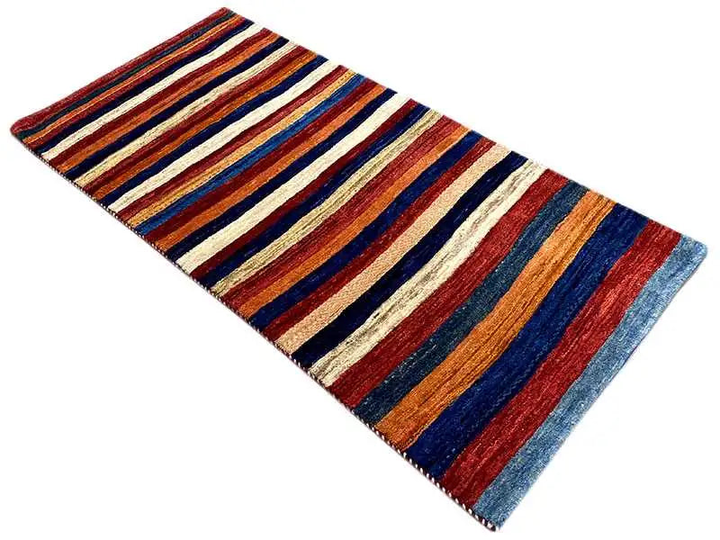 Gabbeh rug, shown at an angle: stripes in blue, red, orange, and cream
