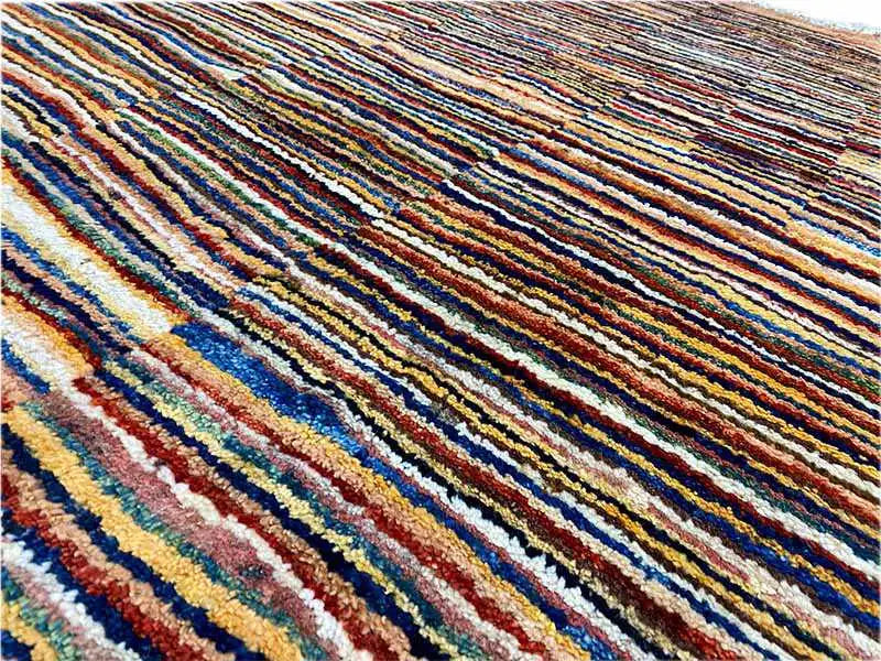 Close-up: multicolored stripes on a densely woven beige carpet