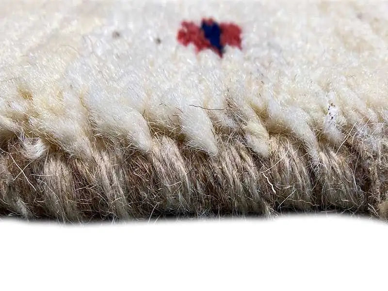 Gabbeh rug detail: rug edge with dense, beige wool pile