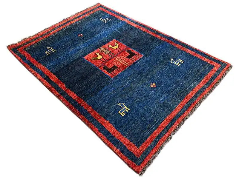 Gabbeh rug, angled: dark blue pile with a red decorative band and central medallion