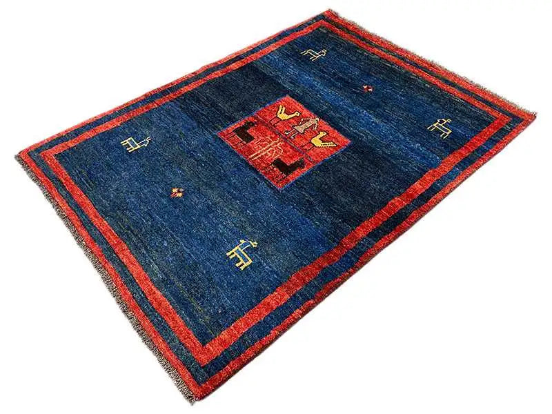 Gabbeh rug with a blue background, red border band, and central red patterned square