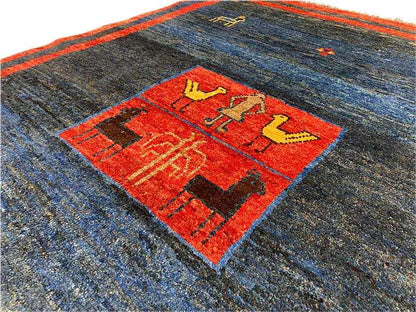 Gabbeh rug detail: dark blue field with a red central motif and a delicate decorative border
