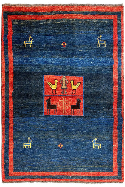 Gabbeh rug with a red border, dark blue background, and symmetrical central motif
